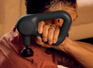 a personal using a TheraGun on their shoulder