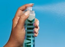 a person spraying a makeup mist 