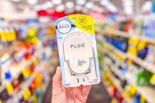person holding a febreze plug oil warmer in an aisle