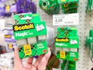 hand holding scotch magic tape 3-pack in front of a target shelf
