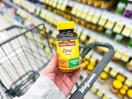 person holding a bottle of zinc tablets over a walgreens cart
