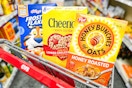 frosted flakes, cheerios, and honey bunches of oats cereal boxes in a cart