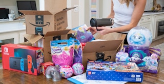 Someone opening a bunch of Amazon packages with gifts to add to their gift stockpile