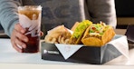person sitting with taco bell box and drink