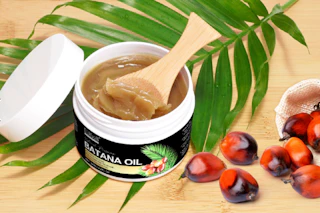 a jar of batana oil on a palm leaf