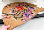 hand grabbing a threshold coir doormat off a target shelf