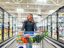 a woman pushing a shopping cart inside the frozen aisle in Walmart 