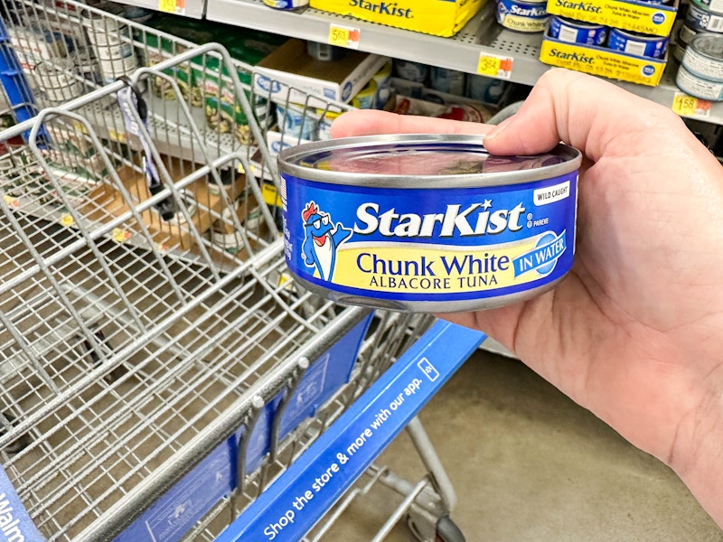 a can of tua being held in store