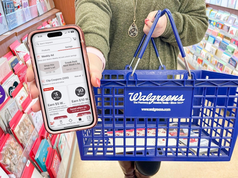 woman holding cellphone with walgreens app while holding walgreens basket