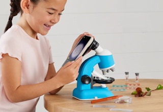 child playing with a blue and white microscope