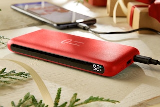 Halo Power Bank with charging cables from QVC sitting on a table plugged into a phone with 92% battery left