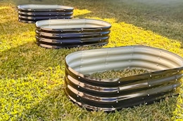 Lifestyle image of three raised garden beds (empty) set up outdoors on the grass