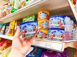 hand holdingblue diamond almonds in front of a target shelf