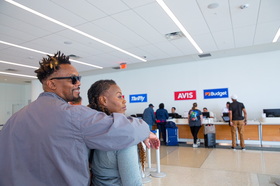 two people waiting in line to rent a car