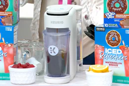 a Keurig coffee maker set next to bowls of fruit