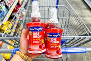 hand holding chloraseptic over walmart cart