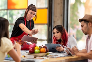A teacher working with students using apple products