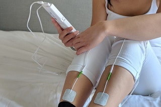 circulation massgaer hooked up to a womans legs while she sits in bed