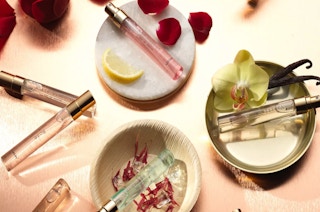 a table with various Lovery fragrance samples, with rose petals around them