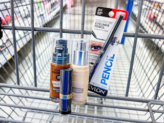 Revlon foundation, lipstick, and eyeliner pencil sitting in a Walmart cart in the beauty area