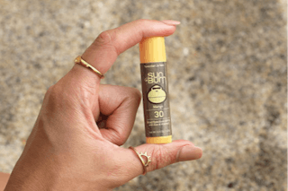 a hand holding a lip balm tube