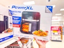 hand grabbing a powerxl air fryer off a target shelf