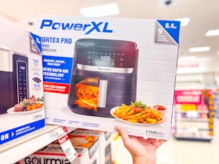 hand grabbing a powerxl air fryer off a target shelf