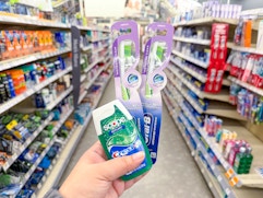 hand holding crest and oral-b items in walgreens