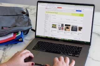 A person using a laptop to search on eBay for school supplies.