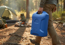 person carrying a blue 6-gallon watering jug to a camp site