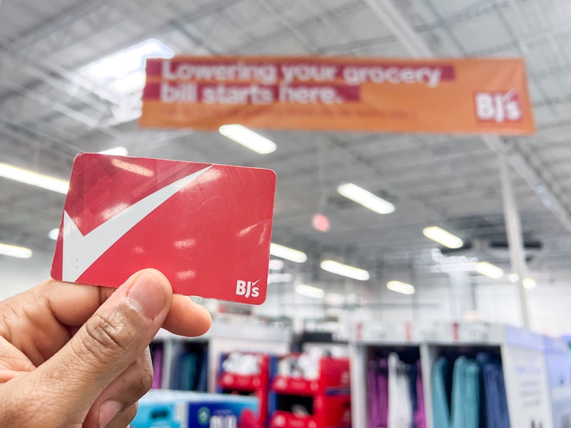 Person holding a Bj's Membership card inside a Bj's Warehouse