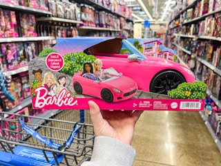 hand holding barbie convertible car toy in walmart toy aisle
