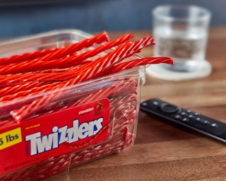 a container of Twizzlers next to a remote