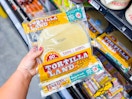hand holding a package of tortillaland tortillas in walmart aisle