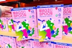 hand grabbing a box of magic spoon cereal at costco