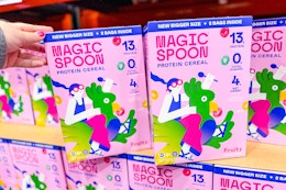 hand grabbing a box of magic spoon cereal at costco