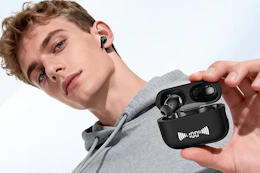 a young man holding wireless earbuds