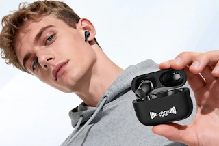 a young man holding wireless earbuds