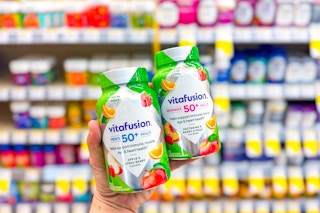 person holding 2 bottles of multivitamins