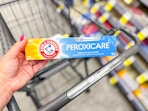 hand holding arm & hammer peroxicare toothpaste in walgreens