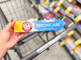 hand holding arm & hammer peroxicare toothpaste in walgreens