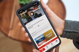 A person looking at a phone displaying the AARP website.