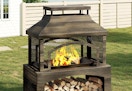 large freestanding fire pit with log storage