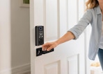 a person opening a door with a digital door lock