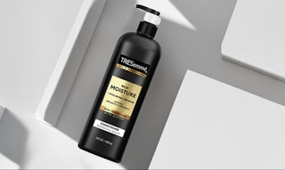 a black and gold bottle of conditioner