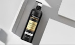 a black and gold bottle of conditioner