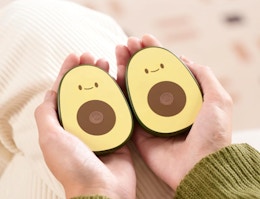 a hand holding avocado hand warmers