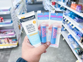 hand holding neutrogena and maybelline products in walgreens