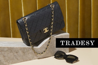A hand bag and sunglasses on a display with the TRADESY logo in black and white.