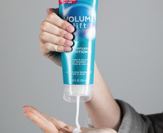 someone pouring conditioner in their hands